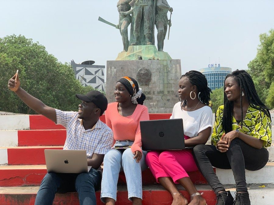Étudiants avec leurs ordinateurs portables sur les marches du campus